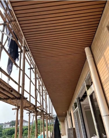 Hengyuan WPC wall panels applied to the exterior eaves and corridor ceilings of modern architecture, showcasing superior flatness and refined texture.